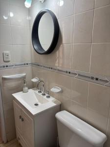 a bathroom with a sink and a mirror and a toilet at El retamo - Casa Turística in San Rafael