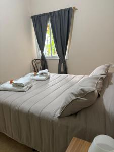 a bed with two towels on it with a window at El retamo - Casa Turística in San Rafael +4 photos