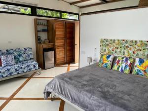 a bedroom with a large bed and a couch at Villas Isla Escondida in Boca Chica +149 photos