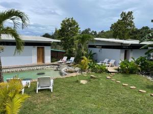 a house with a pool and chairs in the yard at Villas Isla Escondida in Boca Chica