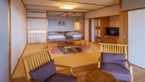 ein Zimmer mit zwei Betten und einem Tisch und Stühlen in der Unterkunft Hamachidorinoyu Kaisyu in Shirahama