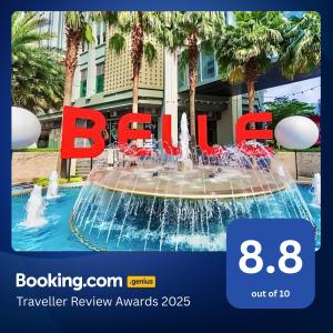 a fountain in front of a hotel with the bayer sign at Belle Grand Rama 9 Bangkok in Bangkok