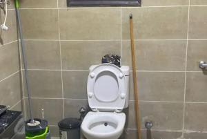 a bathroom with a toilet with a plunger next to it at Metallistix wine in Irvine +5 photos