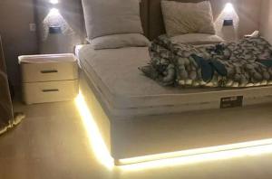 a bedroom with a white bed with lights on it at Metallistix wine in Irvine