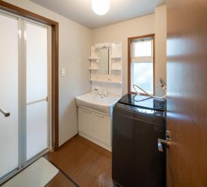 ein Badezimmer mit einem schwarzen Kühlschrank und einem Waschbecken in der Unterkunft SAKURA HOUSE - Vacation STAY 07254v in Hakone + 29 Fotos