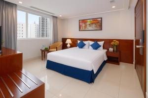 a hotel room with a bed and a television at White Lotus Hotel Saigon in Ho Chi Minh City