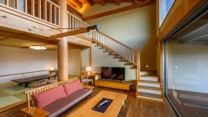 a living room with a couch and a staircase at Hamachidorinoyu Kaisyu in Shirahama