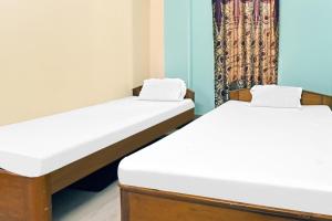 2 Betten in einem Zimmer mit Vorhang in der Unterkunft Hotel O Rainbow in Tezpur + 25 Fotos