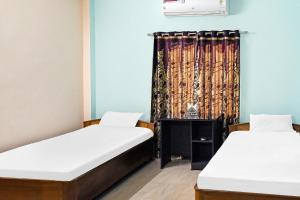 2 Betten in einem Zimmer mit Vorhang in der Unterkunft Hotel O Rainbow in Tezpur