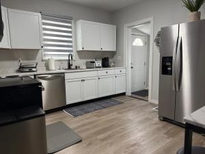 une cuisine avec des armoires blanches et un réfrigérateur en acier inoxydable dans l'établissement Rise & Shine, à Richmond 3 autres photos