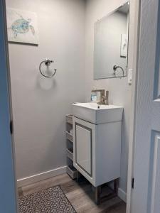 une salle de bains blanche avec un lavabo et un miroir dans l'établissement Rise & Shine, à Richmond