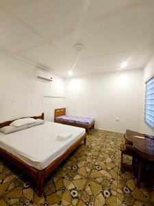 een kamer met twee bedden en een tafel erin bij Rooms in Apo-estin in Cangatuyom