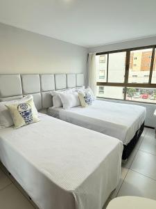 two beds in a room with a window at Luxor Tambau 211 by Viva Hospedagens in Tambaú +27 photos