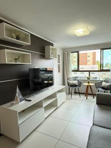 a living room with a television and a couch at Luxor Tambau 211 by Viva Hospedagens in Tambaú