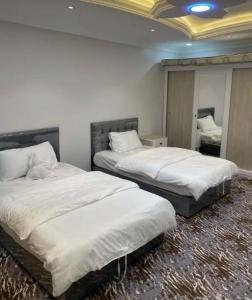 ein Schlafzimmer mit zwei Betten mit weißer Bettwäsche in der Unterkunft VIP Villa in Quai