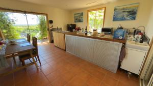 a kitchen and dining room with a table and a counter at Love at Sellicks Chills in Sellicks Hill