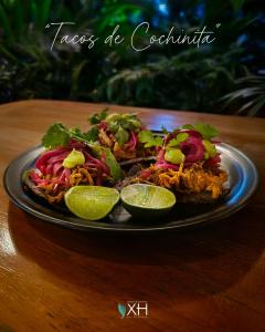 a plate of food on a table with lime slices at MBH Maya Bacalar Hotel Boutique in Bacalar