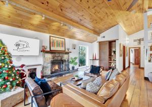 BlakesleeSki Chalet I EV Charger Sauna I Hot Tub I Movie Room & Firepit I PET Friendly的客厅配有圣诞树和壁炉 更多56张照片