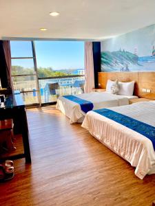 a hotel room with two beds and a large window at Kenting Waterfront Hotel in Kenting +76 photos