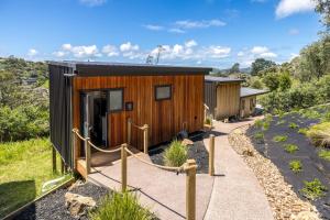 Holzhütte mit Zugang zur Tür in der Unterkunft Hidden Valley Waiheke in Palm Beach