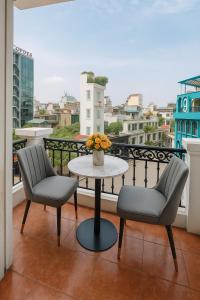 a balcony with two chairs and a table on a balcony at Eco Hotel in Hanoi