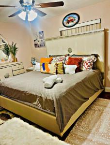 una camera da letto con letto con cuscini e ventilatore a soffitto di Cozy home a Pompano Beach