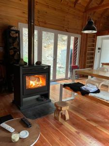 ein Wohnzimmer mit Kamin in einer Blockhütte in der Unterkunft Cabaña sobre el Lago Cholila in Cholila + 15 Fotos