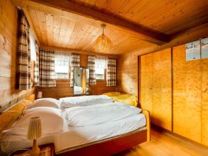 una camera da letto con un grande letto in una camera in legno di Chalet in Jochberg near Thurn Pass Skiing a Jochberg