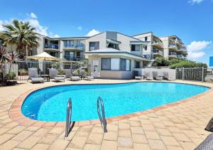 a swimming pool in front of a house at Scarborough Beach Front Resort - Shell Seven in Perth