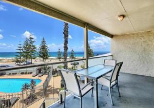 a table and chairs on a balcony with a view of the ocean at Scarborough Beach Front Resort - Shell Seven in Perth