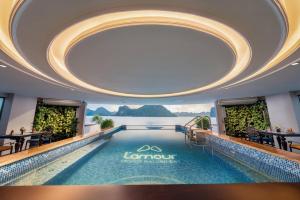 a pool in a hotel lobby with a large ceiling at Lamour Cruise in Ha Long