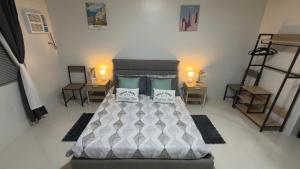 a bedroom with a bed and two tables and chairs at Camella Verdant - Dolcevita Residence in Puerto Princesa City +12 photos