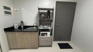 a small kitchen with a sink and a microwave at Camella Verdant - Dolcevita Residence in Puerto Princesa City