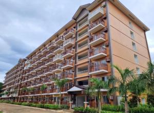 a large apartment building with palm trees in front of it at Camella Verdant - Dolcevita Residence in Puerto Princesa City