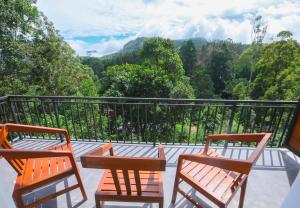 two chairs on a balcony with a view of trees at Ivory Canopy Resort - Ella in Ella