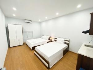 a white room with two beds and a mirror at Eco Hotel in Hanoi +5 photos