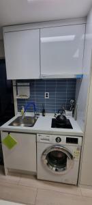 a kitchen with a sink and a washing machine at Bombay Residence SNU Nakseongdae Station in Seoul +34 photos