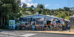ein Restaurant mit Leuten, die davor sitzen in der Unterkunft Hidden Valley Waiheke in Palm Beach
