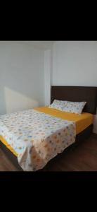 a bedroom with a bed with a comforter on it at Hotel Perezoso in Iquitos