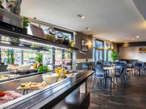 ein Restaurant mit einer Bar mit Tischen und Stühlen in der Unterkunft ibis Styles Paris Bercy in Paris