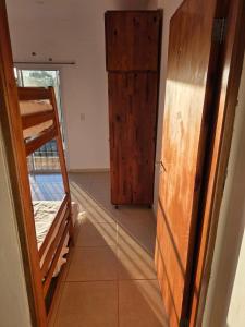 Zimmer mit einem Etagenbett und einer Holztür in der Unterkunft Complejo Cambyretá in Cambyretá