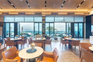 un ristorante con tavoli e sedie e grandi finestre di Hexu Yanju Hotel a Wulong