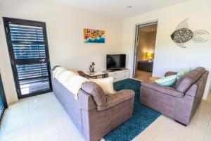 Baywatch unit 2 at 1770 في سفنتين سيفينتي: غرفة معيشة مع أريكتين وتلفزيون