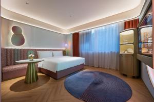 a hotel room with a bed and a table at Qingzhou Ancient City Minxin Hotel in Qingzhou