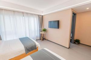a hotel room with a bed and a television at Shan Tao Inn -山韬客栈- Good location-English reception-Ticket service-Tourism planing-coffee-Laundry-kung fu Tea-Drone gopro rental in Zhangjiajie
