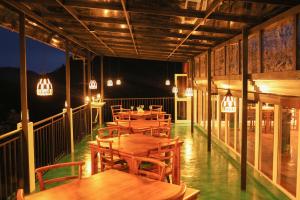 a restaurant with wooden tables and chairs and lights at Ivory Canopy Resort - Ella in Ella