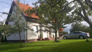 a car parked in front of a white house at Vila Joana in Palanga