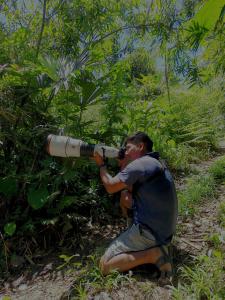 een man met een telescoop in een bos bij mirador pico de hoz lodge in Pillcopata