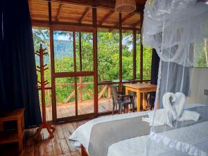 een slaapkamer met een bed en een groot glazen raam bij mirador pico de hoz lodge in Pillcopata