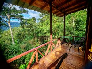 een balkon van een huis met een tafel en stoelen bij mirador pico de hoz lodge in Pillcopata